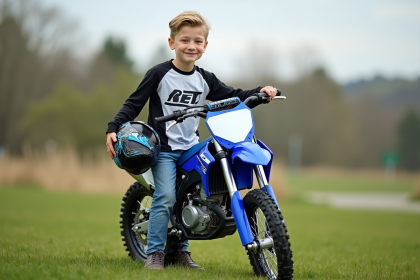 Garçon de 7 ans en motocross souriant avec casque à la main